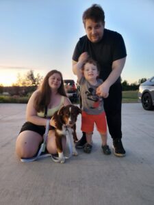 Australian Shepherd puppy sitting outdoors ready to join a new family in Wisconsin